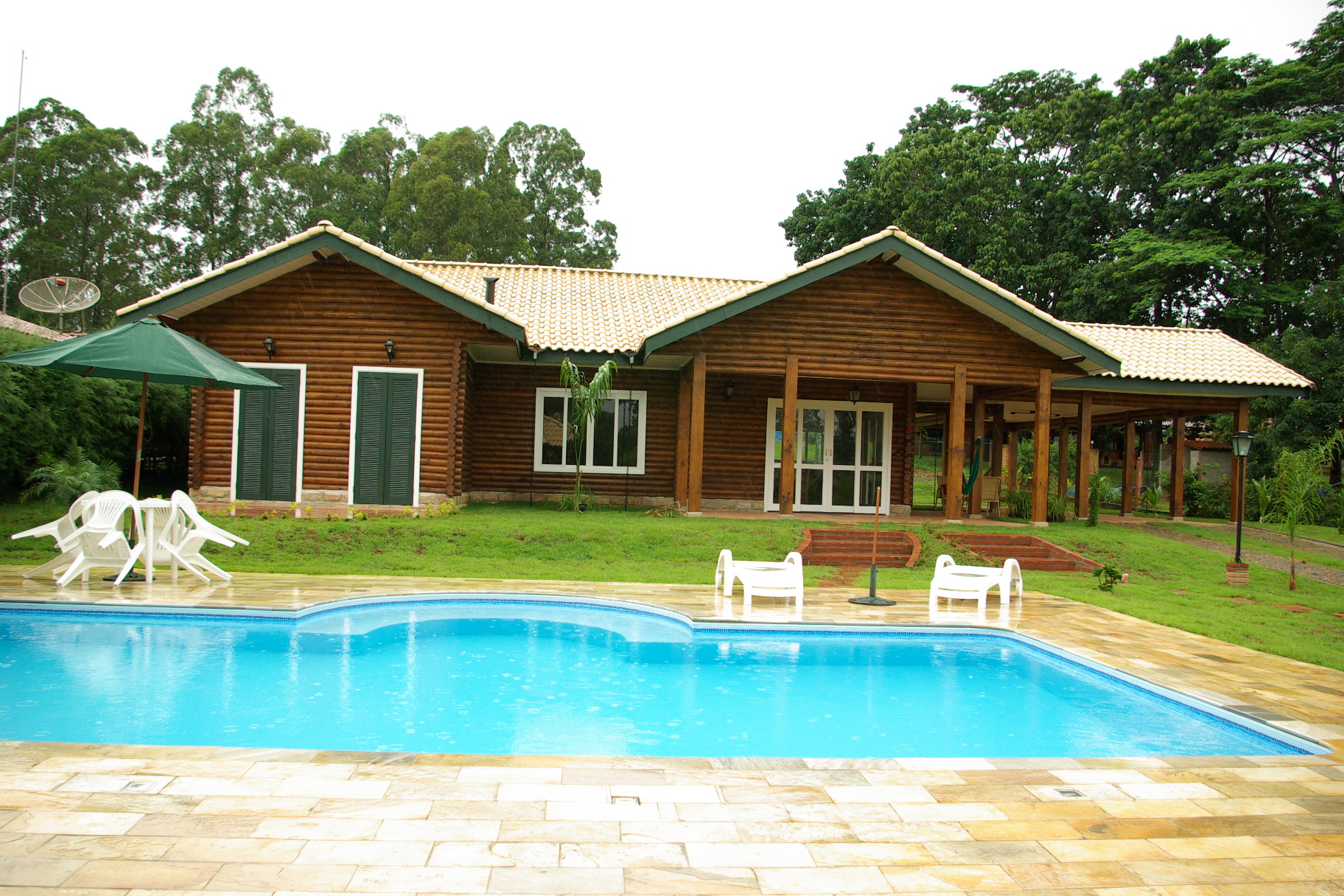 Fachada de log home Casabella com piscina