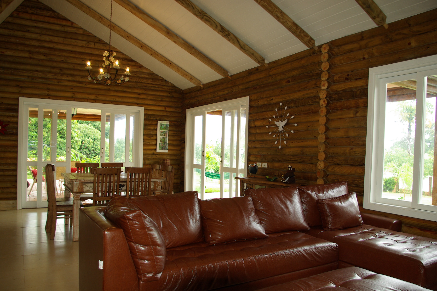 Interior da sala com teto alto e sofás de couro